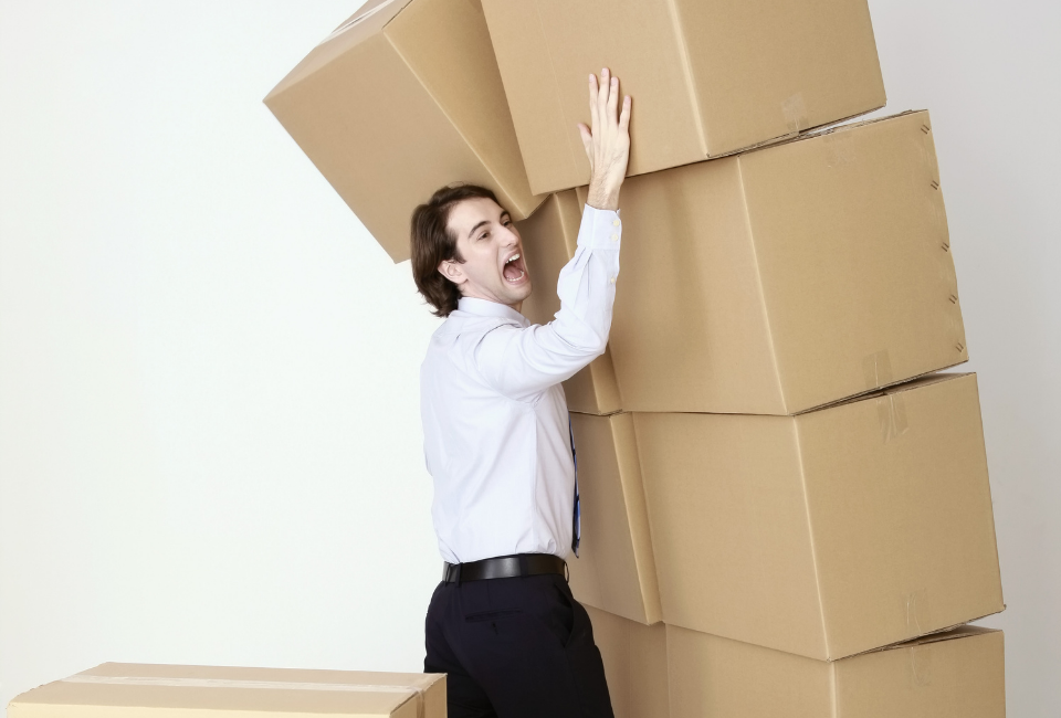 man holding up a pile of boxes